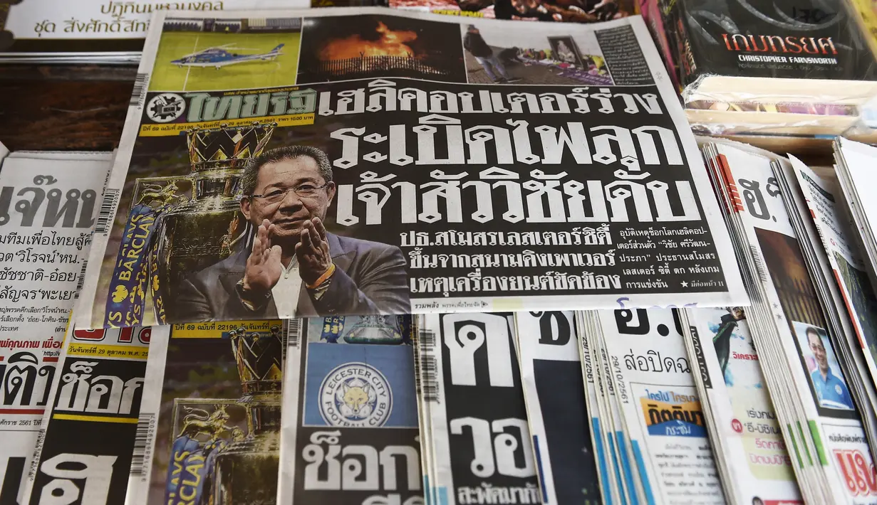Surat kabar Thailand menampilkan berita utama jatuhnya helikopter pemilik klub Liga Inggris Leicester City, Vichai Srivaddhanaprabha di Bangkok, Senin (29/10). Bos Leicester City tewas ketika helikopternya jatuh dan terbakar. (Lillian SUWANRUMPHA/AFP)