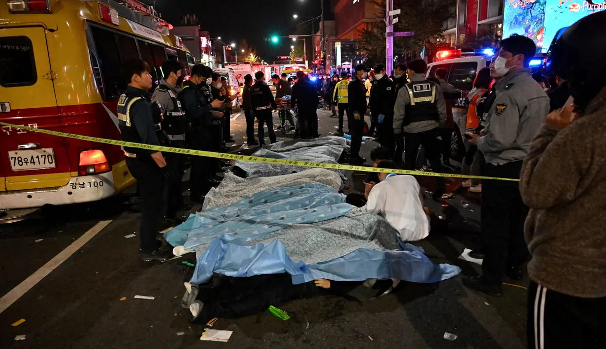 <p>Jenazah para korban, yang diyakini menderita serangan jantung, ditutupi di distrik kehidupan malam populer Itaewon di Seoul, Korea Selatan, Minggu (30/10/2022). Data terbaru yang dirilis pihak berwenang menyebut setidaknya 146 orang telah tewas dan 150 orang lainnya terluka dalam tragedi Halloween Itaewon. (Photo by JUNG YEON-JE / AFP)</p>
