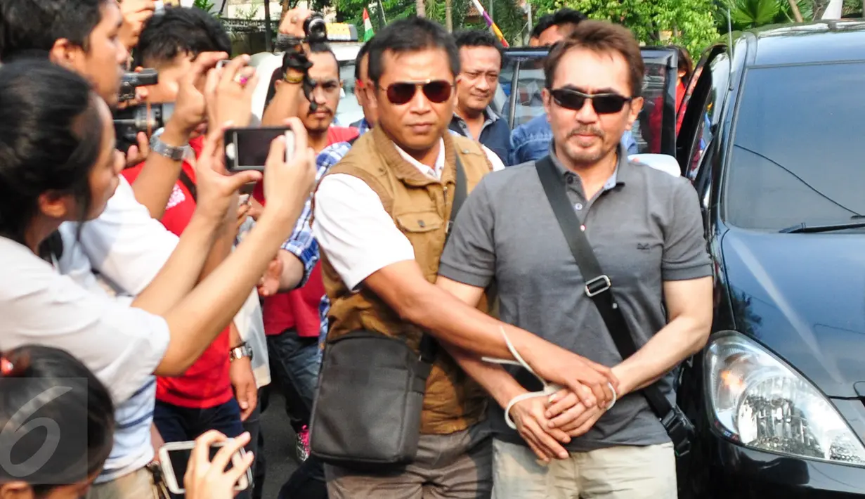 Ketua Umum Persatuan Artis Film Indonesia (PARFI) Gatot Brajamusti alias Aa Gatot dikawal petugas saat tiba di rumahnya di kawasan Pondok Pinang, Jakarta, Kamis (1/9). (Liputan6.com/Yoppy Renato)