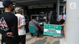 Pelanggar membayar denda saat Sidang Tipiring PPKM Darurat di kantor Kecamatan Pamulang, Tangerang Selatan, Banten, Senin (19/7/2021). Dua puluh empat pelanggar PPKM Darurat diantaranya tidak bermasker dan jam operasional tempat usaha didenda Rp 100 ribu hingga Rp 500 ribu. (merdeka.com/Arie Basuki)