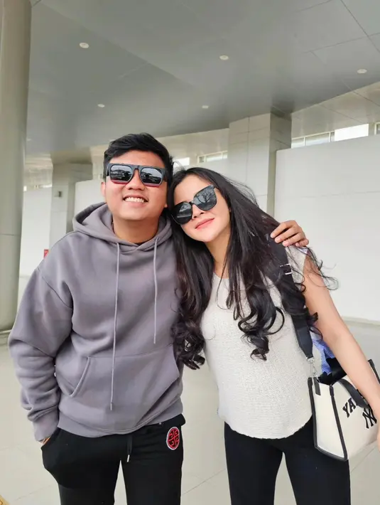 Ini potretnya di bandara, Bella tampil santai dengan knit top putih, long pants hitam, dan sling bag hitam-putih. [@bellabonita_r.a]