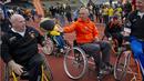Johan Cruyff menaiki kursi roda bersama penyandang disabilitas pada acara Cruyff Foundation di Olympic Stadion, Amsterdam,  Rabu (14/9/2011). Legenda sepak bola itu merupakan sosok yang sangat peduli terhadap kaum disabilitas. (AFP/Marcel Antonisse)