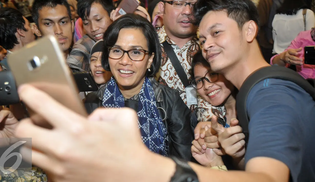 Sejumlah mahasiswa berebut untuk berselfie dengan Menteri Keuangan Sri Mulyani Indrawati, Bandung, Selasa (29/11). Menteri Keuangan RI, Sri Mulyani Indrawati isi kuliah umum bertajuk 'Kenali Anggaran Negeri' di Kampus Unpad. (Liputan6.com/Yoppy Renato)