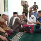 Kepala BPBD Sampang, Anang Djoenaidi saat prosesi mengucap dua kalimat syahadat dibimbing langsung Rois Syuriah PCNU Sampang KH Syafiuddin Abdul Wahid. (liputan6.com/Musthofa Aldo)