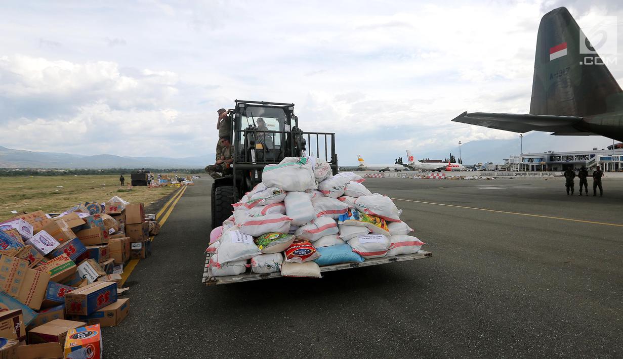 Tentara Amerika Serikat mengangkut bantuan logistik dari landasan menuju Bandara Mutiara Sis Al-Jufri, Palu, Sulawesi Tengah, Minggu (7/10). Bantuan asing tiba menggunakan pesawat Hercules. (Liputan6.com/Fery Pradolo)