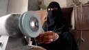 Seorang wanita bernama Safa al-Faqih mengasah batu mulia di tempat kerajinan di Sanaa, Yaman (18/4). Karena perang yang terjadi di Yaman hanya seperempat pengrajin masih bekerja di pasar lama Sanaa. (AFP/Mohammed Huwais)