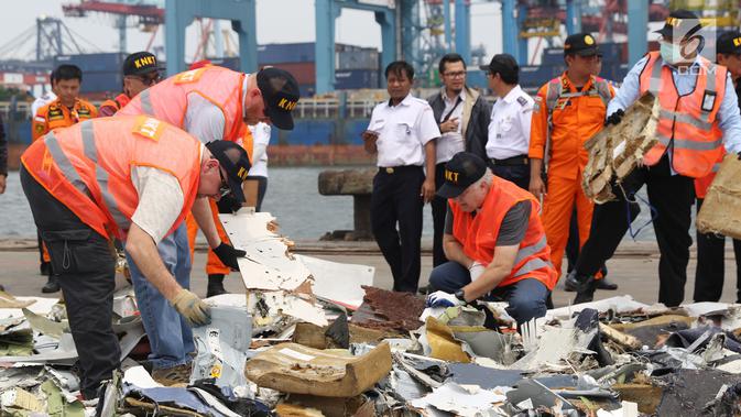 Petugas KNKT mencari dan memisahkan serpihan pesawat Lion Air JT 610 dari tumpukan barang temuan di Pelabuhan JICT 2, Jakarta, Kamis (1/11). Sebelumnya, pesawat Lion Air JT-610 jatuh diperairan utara Kerawang. (Liputan6.com/Helmi Fithriansyah)