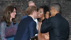 Pangeran Harry saat mencium pipi Michelle Obama saat Presiden AS Barack Obama berkunjung ke Kensington Palace, London , Inggris (22/4). Mereka akan mengadakan acara makan malam. (REUTERS / Kevin Lamarque)