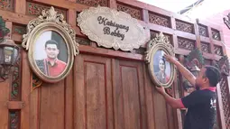Pekerja memasang pigura foto Putri Presiden Joko Widodo Kahiyang Ayu dan Bobby Nasution di Graha Saba, Solo, Senin (6/11). Pernikahan anak presiden tersebut akan berlangsung pada Rabu (8/11) esok. (Liputan6.com/Angga Yuniar)