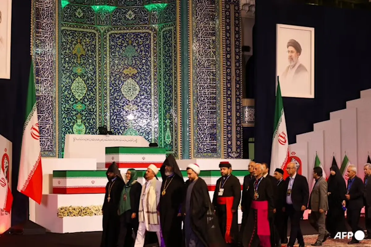 Para pejabat lokal dan asing berjalan melewati peti jenazah Pemimpin Tertinggi Iran Ali Khamenei yang gugur. Mereka memberikan penghormatan terakhir di Grand Mosalla Teheran pada 3 Juli 2026. (Dok. AFP/Atta Kenare)