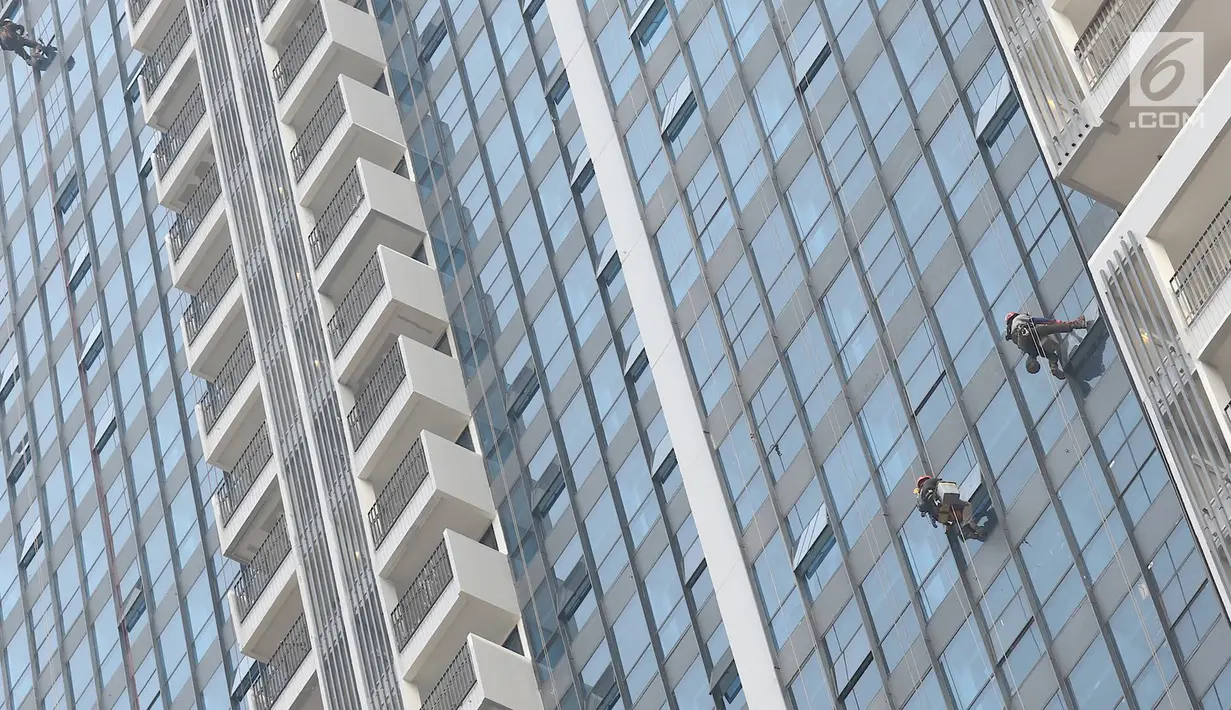 Pekerja membersihkan kaca gedung bertingkat di Jakarta, Kamis (18/10). Kepala Divisi Komunikasi BPJS Ketenagakerjaan Irvansyah Utoh Banja mengatakan, BPJS Ketenagakerjaan menargetkan kepesertaan BPJS Ketenagakerjaan 2018. (Liputan6.com/Immanuel Antonius)