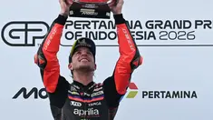 Pembalap Aprilia Racing asal Italia, Marco Bezzecchi, merayakan kemenangan di podium setelah menjuarai balapan MotoGP Indonesia di Sirkuit Internasional Mandalika, Mandalika, Minggu (11/10/2026). (SONNY TUMBELAKA/AFP)