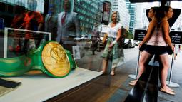 Warga melintas di dekat etalase tempat barang-barang Muhammad Ali dipajang di Heritage Auctions, Manhattan, New York, AS, (19/8). (REUTERS/Eduardo Munoz)
