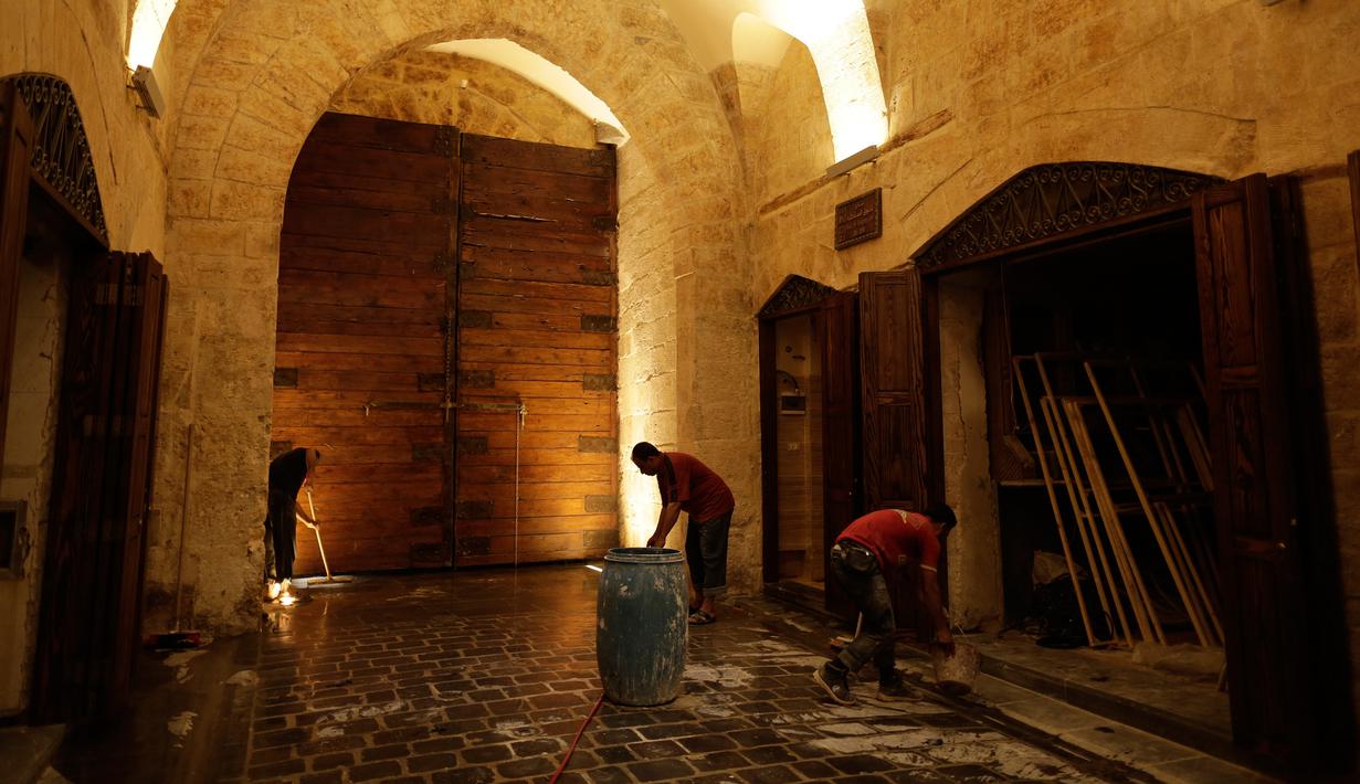 Pekerja membersihkan Pasar al-Saqatiyah yang baru saja direnovasi di Kota Tua Aleppo, Suriah, Sabtu (27/7/2019). Kegiatan ekonomi perlahan mulai tumbuh tiga tahun setelah pertempuran besar terjadi di Aleppo. (AP Photo/Hassan Ammar)