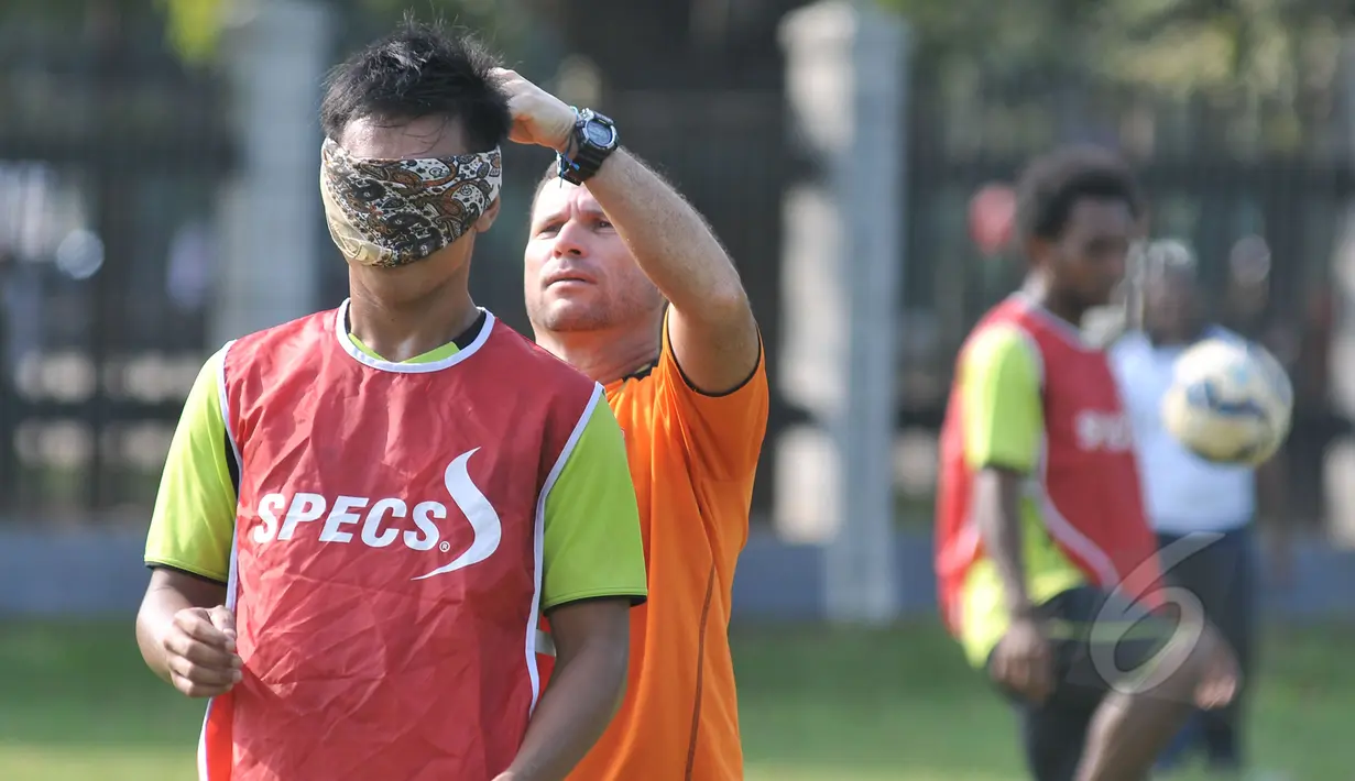 Liputan6.com berkesempatan mengajak pemain Persipura bermain games di Lapangan C Senayan, Jakarta (8/5/2015). Pelatih Oswaldo Lessa (kiri) memakaikan penutup mata ke pemain Persipura sebelum bermain games.  (Liputan6.com/Herman Zakharia)