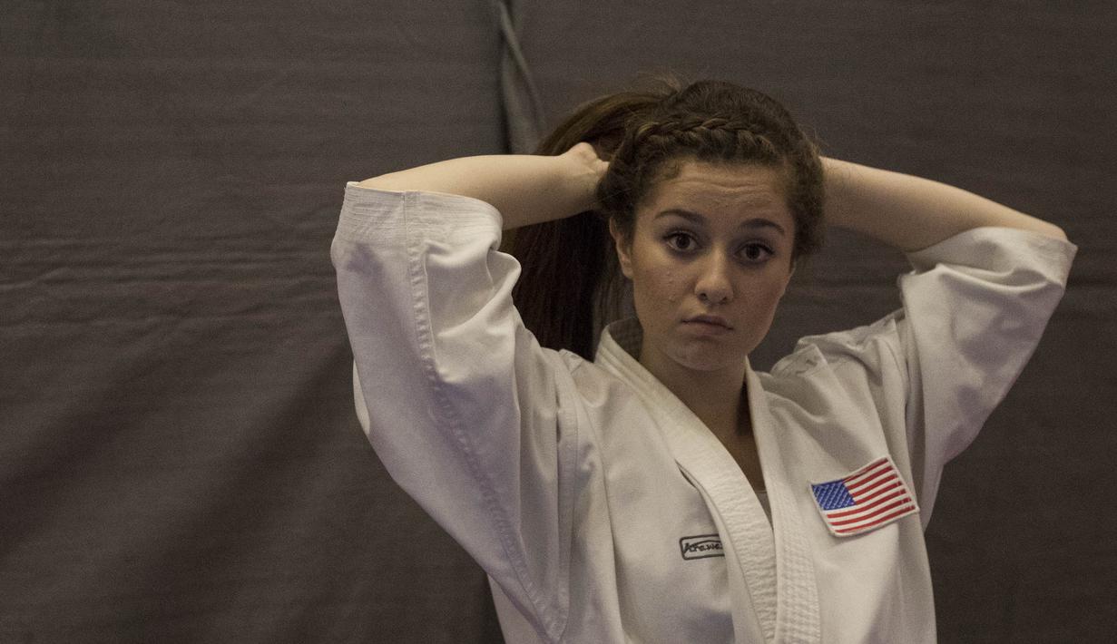 Karate Amerika Serikat merapihkan rambut sebelum tampil pada Kejuaraan Dunia Karate Junior, Cadet, dan U-21 2015. (Bola.com/Vitalias Yogi Trisna)