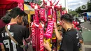 Suporter memilih atribut Timnas Indonesia jelang pertandingan AFF 2022 antara Indonesia melawan Thailand di Stadion Gelora Bung Karno, Jakarta, Kamis (29/12/2022). Atribut timnas Indonesia seperti kaos, syal, dan topi dijual dengan kisaran harga Rp35.000 hingga Rp75.000. (Liputan6.com/Faizal Fanani)