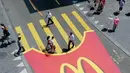 McDonald di Swiss mengecat jalanan dengan desain zebra cross yang unik saat ada festival Zurifest. Satu bungkus kentang goreng berwarna kuning sebagai tempat menyebrang jalan. (sendeyapabilirsin)