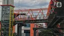 Pekerja menyelesaikan pembangunan jembatan penyeberangan orang (JPO) atau "Skywalk" di kawasan Kebayoran Lama, Jakarta, Sabtu (19/11/2022). Pemprov DKI Jakarta melalui Dinas Bina Marga DKI Jakarta membangun skywalk sepanjang 500 meter dengan desain dan cahaya artistik serta dilengkapi fasilitas lift juga eskalator. (Liputan6.com/Angga Yuniar)
