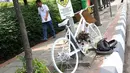 Pejalan kaki melintasi monumen sepeda putih atau ghost bike di sebuah tiang kawasan Jenderal Gatot Subroto, Jakarta, Senin (12/3). Monumen itu untuk mengenang pesepeda Raden Sandy Syafiek yang tewas tertabrak mobil. (Liputan6.com/Immanuel Antonius)