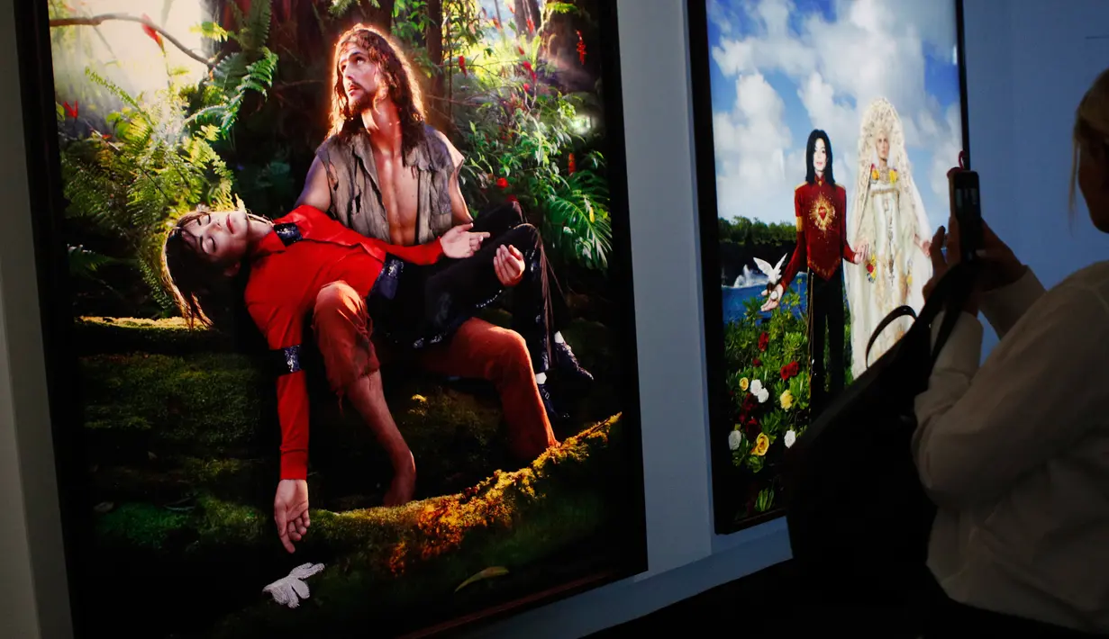 Pengunjung melihat lukisan "American Jesus" dan "The Beatification" (2009) karya seniman Amerika, David LaChapelle dalam pameran Michael Jackson: On The Wall di museum Grand Palais, Paris, Rabu (21/11). (AP/Francois Mori)