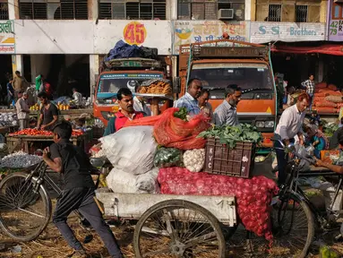 Seorang pekerja muda menarik sayuran di atas becaknya di pasar grosir buah dan sayuran di New Delhi, India (27/3). Delhi telah sejak zaman sejarah tetap menjadi tujuan favorit bagi pembeli. (AFP Photo/Noemi Cassanelli)