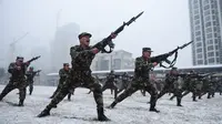 Polisi militer saat mengikuti sesi pelatihan menggunakan senapan berpisau di tengah hujan salju di Hefei, China (15/1/2020). Latihan fisik yang dilakukan anggota polisi militer China meliput angkat ban traktor hingga teknik menyerang dengan menggunakan senapan berpisau. (AFP Photo/Str/China Out)