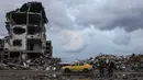 Di sisi lain, Perserikatan Bangsa Bangsa (PBB) memperkirakan, sejak konflik antara Israel dan Hamas dimulai pada Oktober 2023 lalu, sekitar 92 persen dari seluruh bangunan tempat tinggal di Gaza telah rusak atau hancur. Tampak dalam foto, seorang pria mengendarai mobil kuning di samping genangan air di lingkungan Al-Saftawi, sebelah barat kota Jabalia di Jalur Gaza utara pada Rabu 10 Desember 2025. (BASHAR TALEB/AFP)