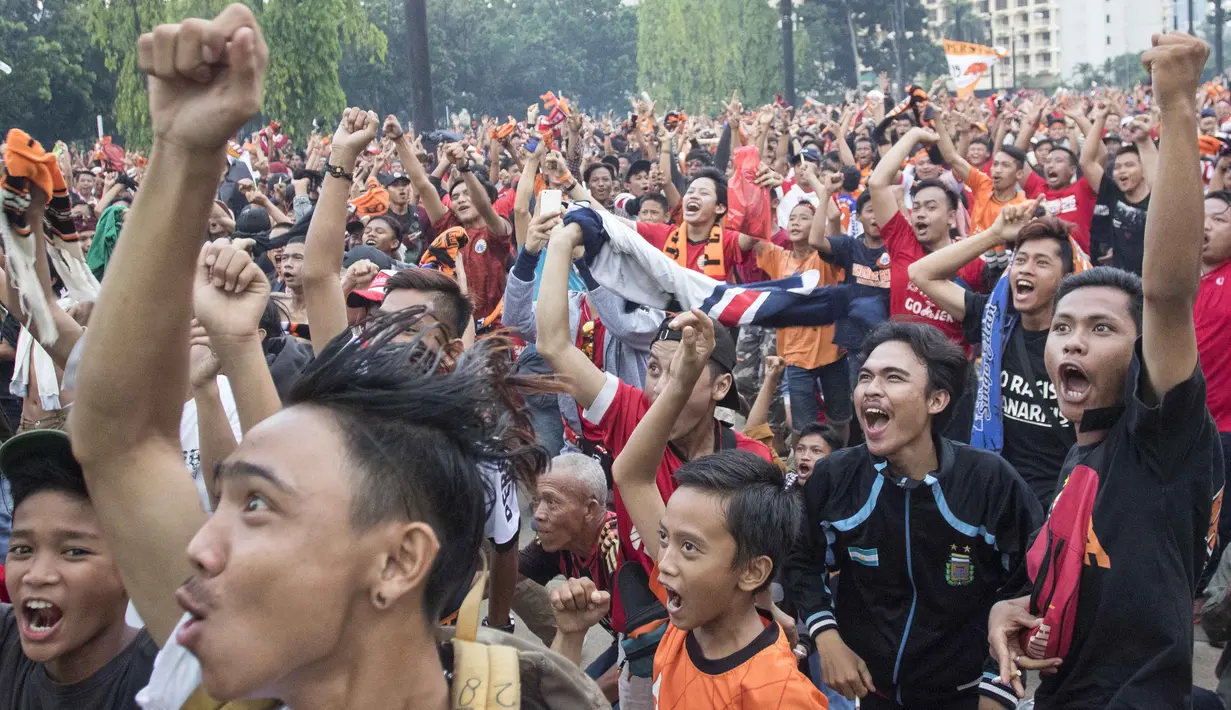 Suporter Persija Jakarta, The Jakmania, merayakan gelar juara Liga 1 saat nonton bareng di Plaza Timur Senayan, Jakarta, Minggu (9/12). Persija juara Liga 1 setelah menang 2-1 atas Mitra Kukar. (Bola.com/Peksi Cahyo)