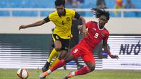 Pemain Timnas Indonesia, Ronaldo Kwateh, berebut bola dengan pemain Malaysia, Muhammad Azam, pada laga perebutan medali perunggu SEA Games 2021 yang digelar di Stadion My Dinh, Hanoi, Minggu (22/5/2022). (AFP/ Ye Aung Thu)