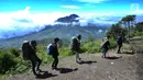 Para pendaki melintasi pemandangan Gunung Merapi dari atas Gunung Merbabu di Selo, Boyolali, Jawa Tengah, Sabtu (2/2/2019). Aktivitas Gunung Merapi dalam beberapa hari terakhir masih tinggi dan masih berada di level 2 atau waspada. (Merdeka/Arie Basuki)