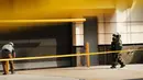 Penjinak bom berjalan untuk memeriksa paket mencurigakan di dekat Hilton Garden Hotel di Washington, DC.AS (19/1). Pihak kepolisian mengatakan Paket tersebut bukan bom melainkan sebuah alarm mainan. (AFP Photo/Andrew Caballero-Reynolds)