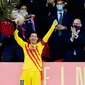 Striker Barcelona, Lionel Messi, mengangkat trofi usai menjuarai Copa del Rey di Stadion Olimpico de Sevilla, Minggu (18/4/2021). Barcelona menang 4-0 atas Athletic Bilbao. (AFP/Cristina Quicler)