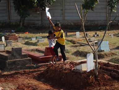 Anak-anak bermain di sekitar Taman Pemakaman Umum (TPU) Karet Bivak, Jakarta, Selasa (10/9/2019). Keterbatasan ruang terbuka hijau memaksa sebagian anak-anak di Ibu Kota bermain tidak pada tempatnya, meskipun dalam kondisi yang tidak layak. (Liputan6.com/Immanuel Antonius)
