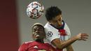 Gelandang Manchester United, Paul Pogba (kiri), berduel udara dengan bek Paris Saint-Germain, Marquinhos, dalam laga lanjutan Liga Champions 2020/21 Grup H di Old Tarfford Stadium, Manchester, Rabu (2/12/2020) waktu setempat. Manchester United kalah 1-3 dari PSG. (AP/Dave Thompson)