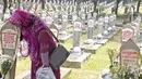 Warga mencium batu nisan di makam Hasri Ainun Besari yang bersebelah dengan makam sang suami,  Presiden ke-3 RI BJ Habibie di TMP Kalibata, Jakarta, Jumat (13/9/2019). Sesuai permintaannya semasa hidup, BJ Habibie dimakamkan bersebelahan dengan mendiang istrinya Ainun. (Liputan6.com/Herman Zakharia)