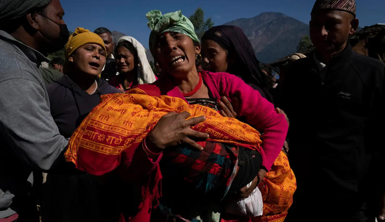 Seorang wanita menggendong jenazah cucunya yang tewas akibat gempa bumi di Distrik Jajarkot, barat laut Nepal, Minggu (5/11/2023). Gempa bumi Jumat malam di distrik tersebut menewaskan lebih dari 100 orang, sementara lebih dari 50 orang tewas di distrik tetangga Rukum, kata para pejabat. (AP Photo/Niranjan Shrestha)