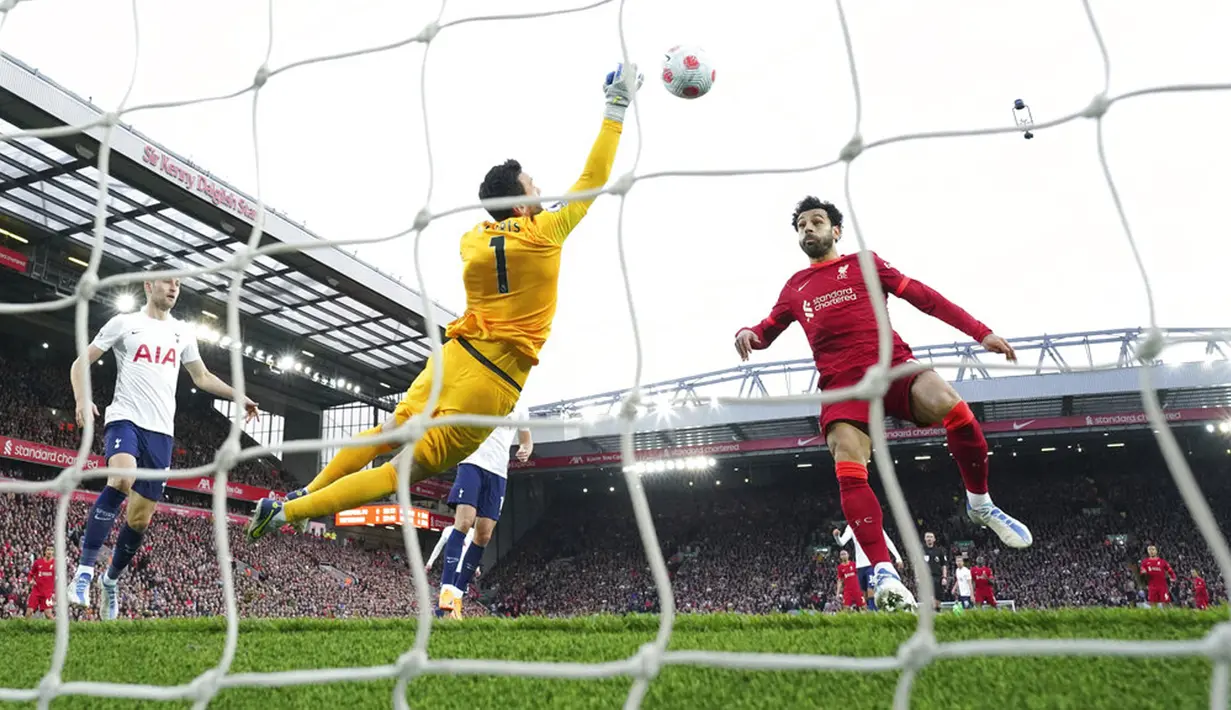 <p>Penjaga gawang Tottenham Hotspur Hugo Lloris (kiri) melakukan penyelamatan di depan pemain Liverpool Mohamed Salah pada pertandingan sepak bola Liga Inggris di Stadion Anfield, Liverpool, Inggris, 7 Mei 2022. Pertandingan berakhir imbang 1-1. (AP Photo/Jon Super)</p>