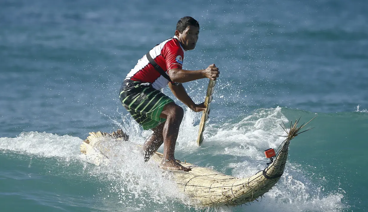 Peselancar Peru, Carlos ' Huevito ' Areola menerjang ombak menggunakan Caballito atau disebut kuda kecil di pantai Bondi, Sydney, (24/2). Areola merupakan kelompok peselancar Peru yang sedang mempromosikan Caballito. (REUTERS / Jason Reed)