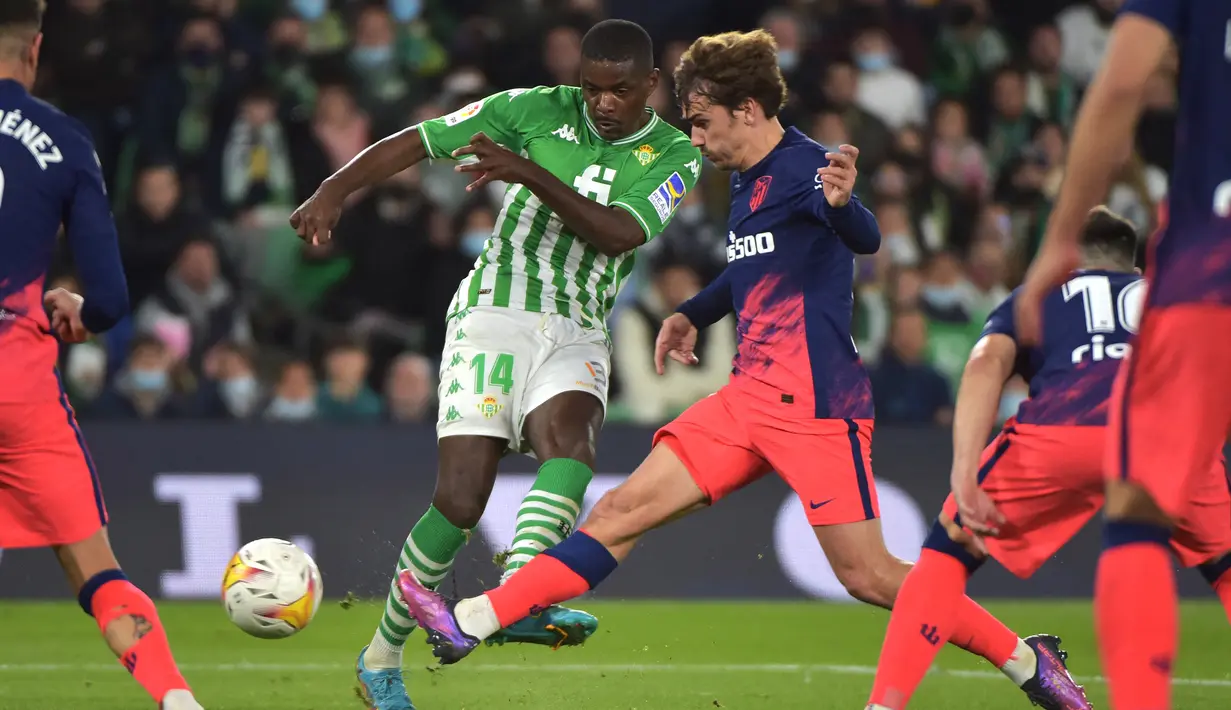 Gelandang Real Betis William Carvalho (kiri) berebut bola dengan penyerang Atletico Madrid Antoine Griezmann pada laga Pekan Ke-27 La Liga Spanyol di Estadio Benito Villamarin, Sevilla, Senin (7/3/2022) dini hari WIB. Atletico Madrid menang 3-1 atas Real Betis. (CRISTINA QUICLER / AFP)