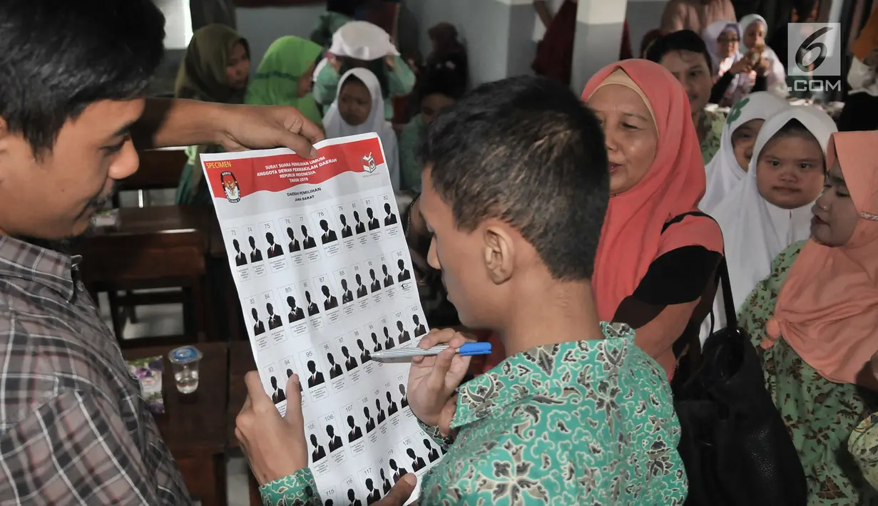 Pemilih pemula penyandang disabilitas mencoba mencoblos surat suara saat KPUD Bekasi menggelar sosialisasi Pemilu 2019 di SLB Al Gaffar Guchany, Bekasi, Rabu (20/2). (Merdeka.com/Iqbal Nugroho)