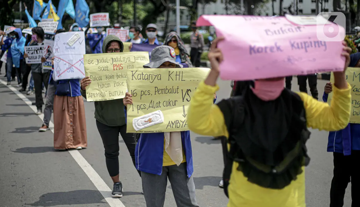 Massa Gabungan Serikat Buruh Indonesia (GSBI) membawa pembalut wanita saat berunjuk rasa di kawasan Patung Kuda, Jakarta, Senin (16/11/2020). GSBI meminta pemerintah mencabut UU Cipta Kerja serta menaikkan upah buruh 2021 sesuai kebutuhan rill buruh dan keluarga. (Liputan6.com/Faizal Fanani)