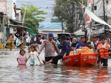 Personel kepolisian mengawal pemberian bantuan makanan siap saji kepada warga terdampak banjir rob di pemukiman padat penduduk Muara Angke, Jakarta Utara, Minggu (15/12/2024). (Liputan6.com/Herman Zakharia)