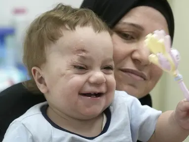 Dalam foto tanggal 14 Agustus 2024 ini, bayi Palestina berusia 10 bulan, Mostafa Qadoura, bermain dengan neneknya, Amna Abd Rabou, di Rumah Sakit Ibu Kota Administrasi Baru, di luar Kairo, Mesir. (AP Photo/Amr Nabil)