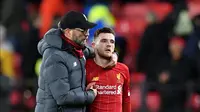 Manajer Liverpool Jurgen Klopp (kiri) merangkul pemain Liverpool Andrew Robertson usai dikalahkan Watford pada pertandingan Liga Inggris di Vicarage Road Stadium, Watford, Inggris, Sabtu (29/2/2020). Watford membantai Liverpool 3-0. (Justin TALLIS/AFP)