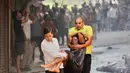 Salah satu keluarga warga negara asing tergantung di jendela hotel saat api melalap bangunan sebuah hotel di New Delhi, India, Rabu 3 Juni 2026. (AP Photo/Manish Swarup)