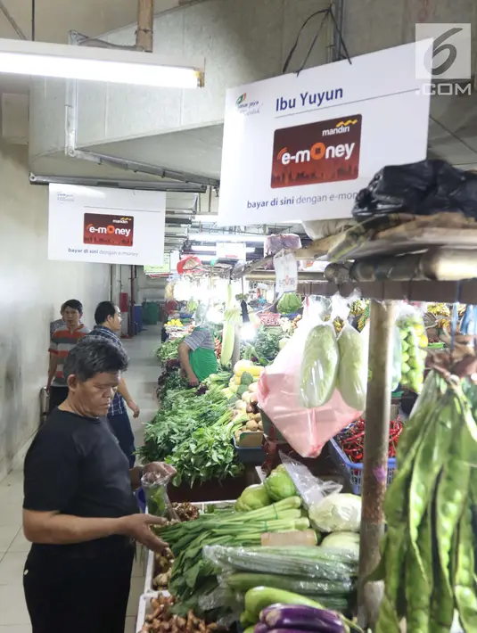 Pedagang menata dagangannya di PD Pasar Jaya  Mayestik, Jakarta, Rabu (4/4). Bank Mandiri bersinergi dengan PD. Pasar Jaya mengimplementasi transaksi nontunai dengan menggunakan E-Money dan mesin Q Cash. (Liputan6.com/Angga Yuniar)