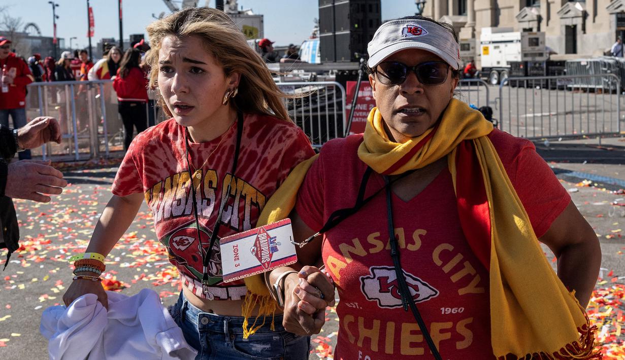 Ekspresi panik sejumlah warga saat tragedi penembakan di parade kemenangan Kansas City Chiefs setelah memenangkan Super Bowl LVIII di Kansas City, Missouri, Amerika Serikat, Rabu (14/02/2024) waktu setempat. Sebanyak 21 orang terluka dan satu orang meninggal dunia akibat teror tersebut. (AFP/Andrew Caballero-Reynolds)