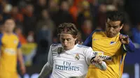 Pemain Real Madrid, Luka Modric (kiri) melewati adangan pemain APOEL, Nuno Morais pada laga Liga Champions grup H di GSP stadium, Nicosia, (21/11/2017). Madrid menang 6-0. (AP/Petros Karadjias)