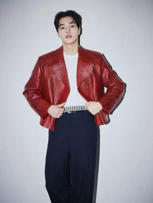 Lagi, pesona Song Kang dengan outfit berwarna merah. Di sini, ia mengenakan kaus putih dipadu celana panjang bergaris berwarna biru navy, ditumpuk dengan leather jacket merah. [Foto: Instagram/songkang_b]